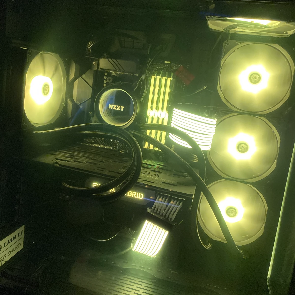 Custom PC build with gold-toned RGB lighting inside a Lian Li case